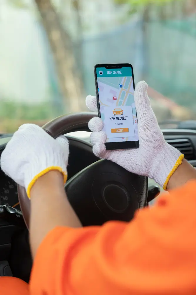 photo of a taxi driver from keralacabs looking for a new booking received on mobile phone for taxi service in trivandrum